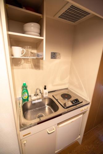a small kitchen with a sink and a stove at Vail sta Takenotsuka in Tokyo