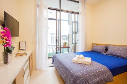- une chambre avec un lit, un canapé et une fenêtre dans l'établissement Jen & Friends House, à Hô-Chi-Minh-Ville