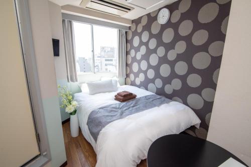 a bedroom with a bed with a polka dot wall at Vail sta Takenotsuka in Tokyo