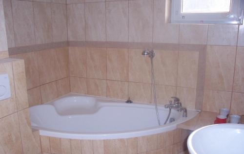 a bath tub in a bathroom with a sink at Gosciniec Nad Stawem in Szczytno