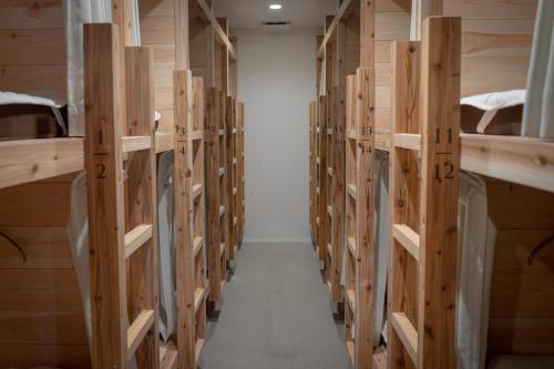 a row of wooden shelves in a room at FOLK FOLK Hostel, Cafe & Bar in Ise