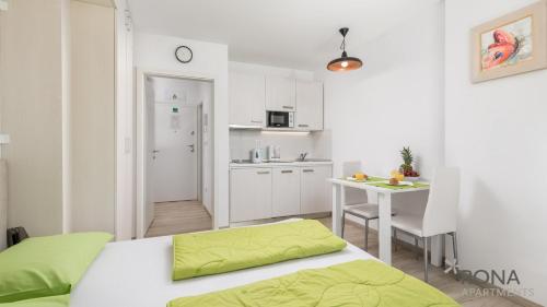 a bedroom with a bed and a table and a kitchen at Rona Studio Apartment Tena in Lovran