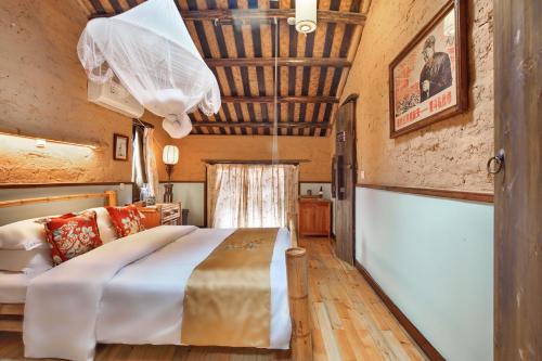 a bedroom with a large bed and a wooden ceiling at Yangshuo Village Inn Boutique Hotel in Yangshuo