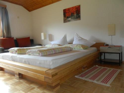 グルントルゼーにあるEgglmeier's Ferienwohnungのベッドルーム1室(木枠の大型ベッド1台付)