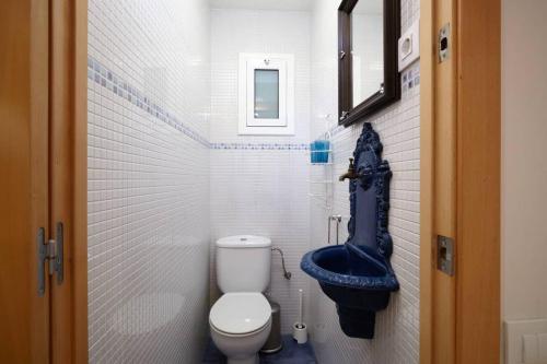 a small bathroom with a toilet and a blue seat at Beautiful apartment in Eixample in Barcelona