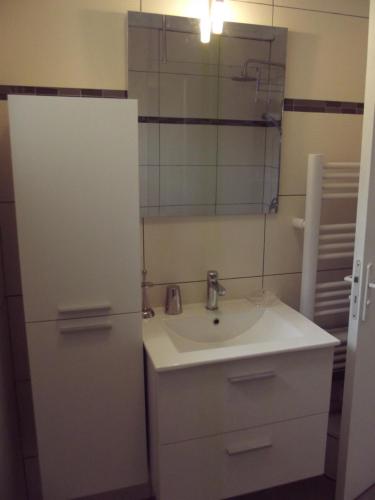La salle de bains est pourvue d'un lavabo et d'un miroir. dans l'établissement Petite maison, à Gabarret