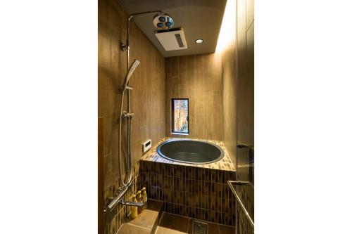 a bathroom with a tub and a shower at Bonbori an Machiya House in Kyoto