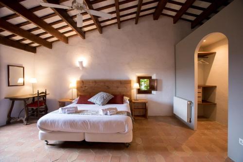 a bedroom with a large bed and a table at Alquiler de casa rural completa: Masía del siglo XV en la Costa Brava in Santa Cristina d'Aro