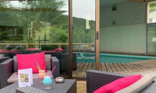 patio z różowymi poduszkami i basenem w obiekcie Hotel Le Panorama w mieście Mont-Dore