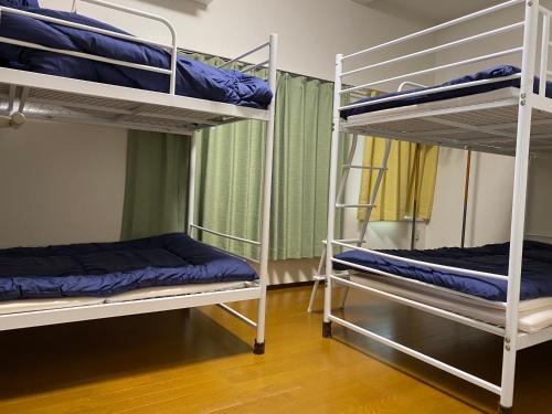 a room with two bunk beds in a dorm room at Akitaya Annex in Kamakura