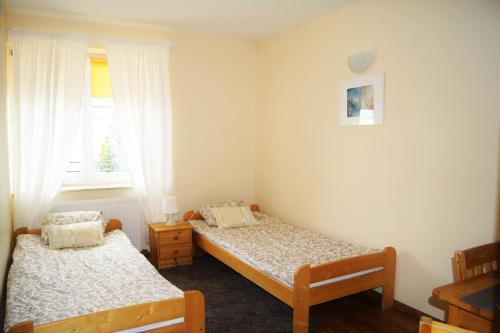 1 dormitorio con 2 camas y ventana en Willa Ostoja, en Lublin