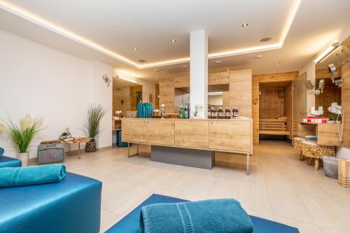 a living room with a blue couch and a counter at Enjoy The Alps in Flachau