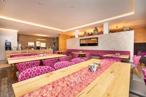 a restaurant with pink chairs and a bar at Enjoy The Alps in Flachau