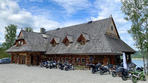 a group of motorcycles parked in front of a log cabin at Ostoja Spokoju in Olchowiec