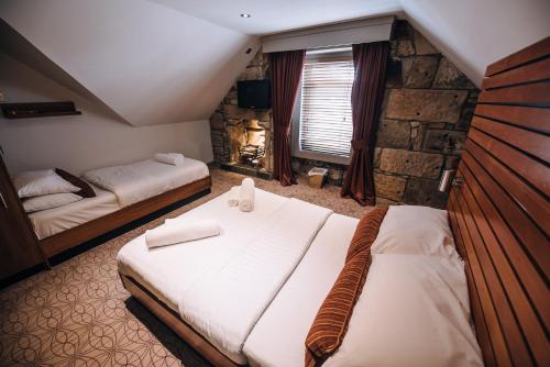 a bedroom with two beds and a stone wall at The Commercial Hotel in Wishaw