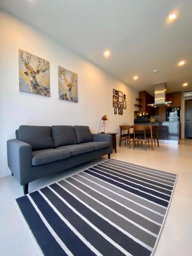 a living room with a blue couch and a rug at Escape Condominiums Beachfront Suites - Mae Phim in Rayong