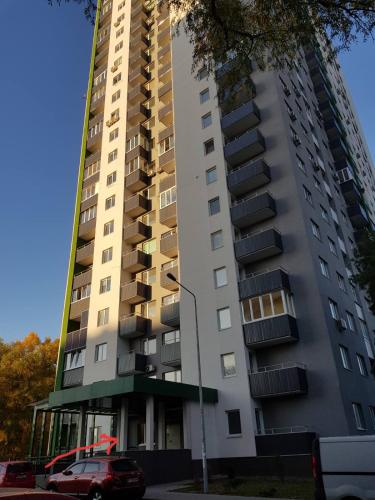 a tall building with a car parked in front of it at Теремки in Kyiv