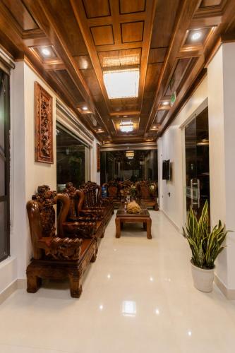 a lobby with couches and tables in a building at Bamboo Green Hotel in Dong Hoi