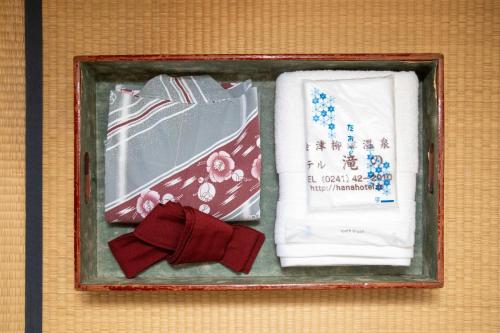 a frame with a bow tie and some napkins at Tabist Hana Hotel Takinoya Aizu-Yanaizu in Yanaizu