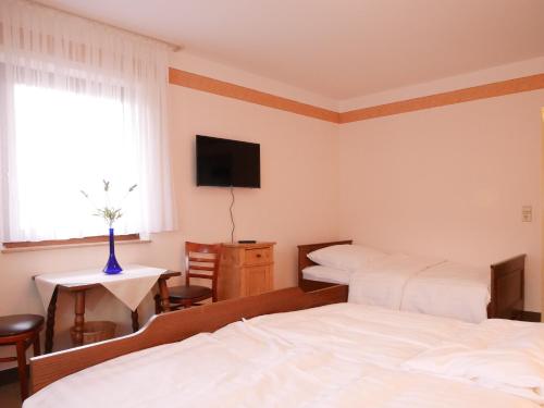 a hotel room with two beds and a television at Gasthaus Engel in Bühlertal