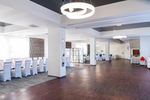 a conference room with white chairs and tables at Hotel Horyzont in Rzeszów