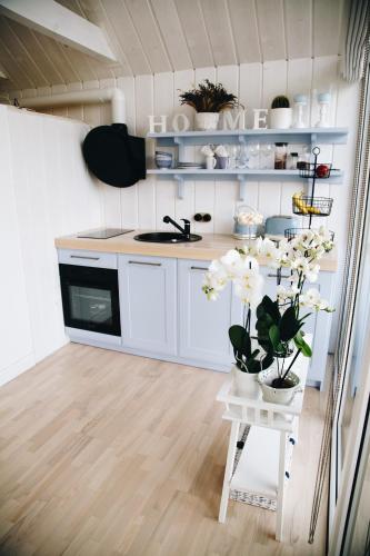 a kitchen with white cabinets and white flowers on a table at RELAX PORT in Bigauņciems
