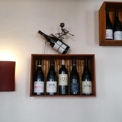 une étagère avec des bouteilles de vin sur un mur dans l'établissement Hotel Auberge Edelweiss, à La Grave