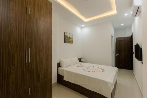 a bedroom with a bed and a brown cabinet at Bamboo Green Hotel in Dong Hoi