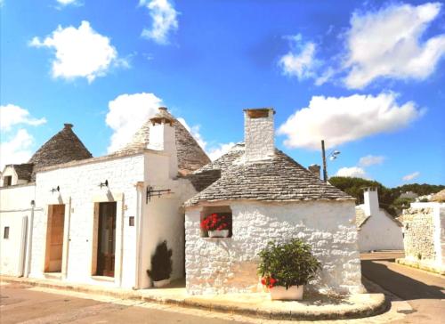 an old white building with a roof at Trulli Resort Dimore Storiche in Alberobello