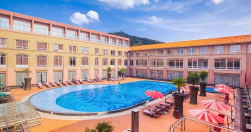 a hotel with a large swimming pool in front of a building at Easeland Hotel Guangzhou in Guangzhou