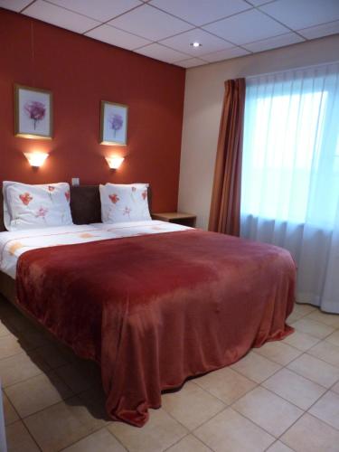 een slaapkamer met een groot bed met rode muren bij Wildenborcherhof in Vorden