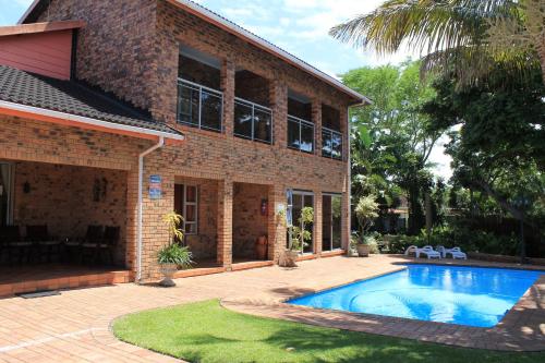 una casa con piscina frente a ella en DuneSide Guest House, en Richards Bay