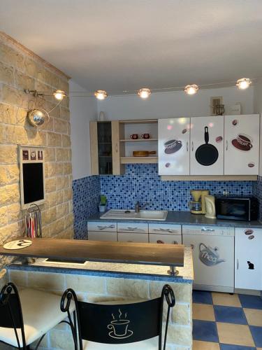 une cuisine avec des armoires blanches et un comptoir dans l'établissement Résidence ST Clément, à Metz