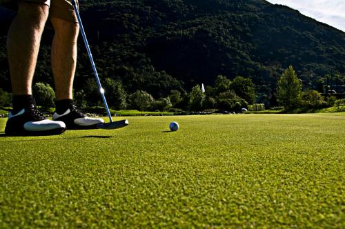 a person is playing golf on a golf course at Parkhotel Delta, Wellbeing Resort in Ascona