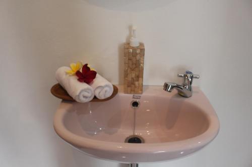 umywalkę w łazience z ręcznikami i świecą w obiekcie Intan Guest House w mieście Ubud