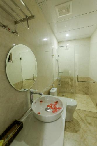 a bathroom with a sink and a toilet and a mirror at Bamboo Green Hotel in Dong Hoi