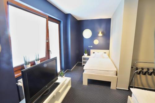 a hotel room with a bed and a tv at Apart Hotel Jablonec in Jablonec nad Nisou
