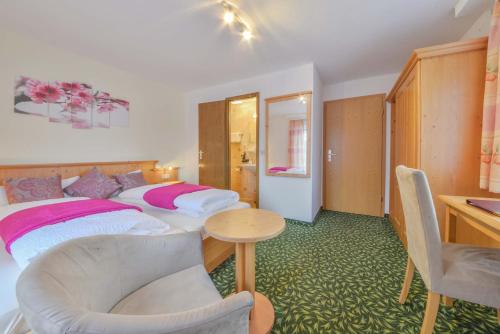 a hotel room with two beds and a table at Pension Freiheit in Pfronten