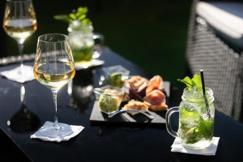 a table with a glass of wine and a plate of food at Best Western Hotel Mediterranee Menton in Menton