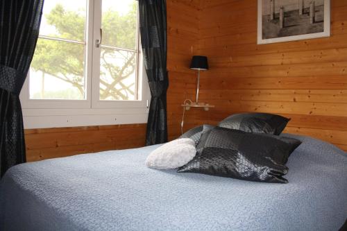 a bedroom with a bed with black pillows and a window at Cottage Nieuwkoop in Nieuwkoop