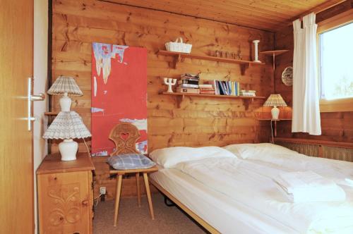 ein Schlafzimmer mit einem Bett und einer Holzwand in der Unterkunft Chalet Trollius in Bettmeralp