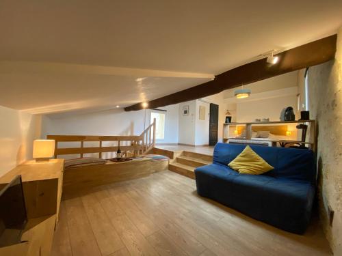 a living room with a blue couch in a room at Logis des Jurats in Saint-Émilion