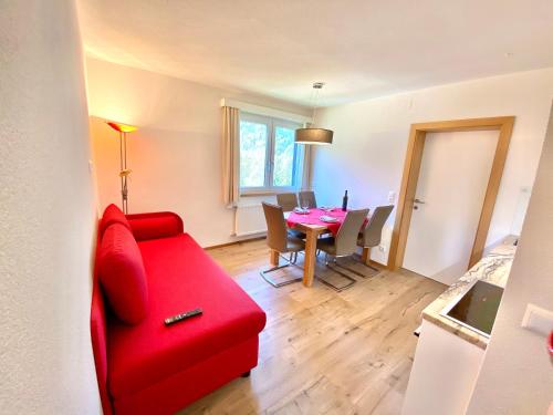 ein Wohnzimmer mit einem roten Sofa und einem Tisch in der Unterkunft Loft in Wasserstrasse in Bad Kleinkirchheim