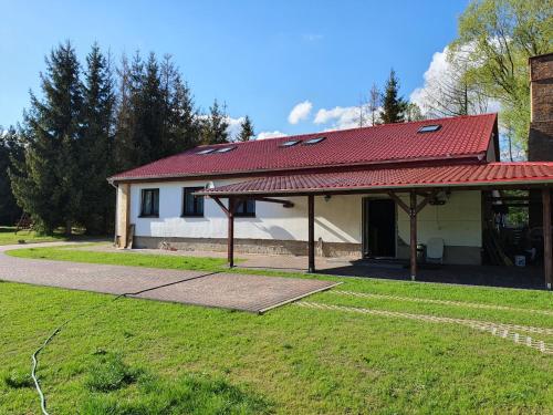 a small white house with a red roof at Newland Wójtowicz in Debrznica