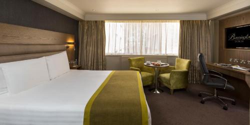 ダブリンにあるボニントン ホテル＆レジャー センターのベッド、テーブル、椅子が備わるホテルルームです。