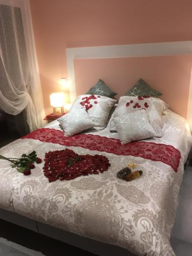 a bed with white and red flowers on it at L'échappée Saline in Saint-Molf