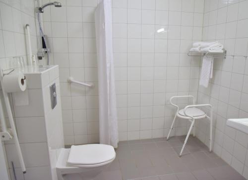 a white toilet sitting next to a white sink at Hotell Charlottenberg in Charlottenberg