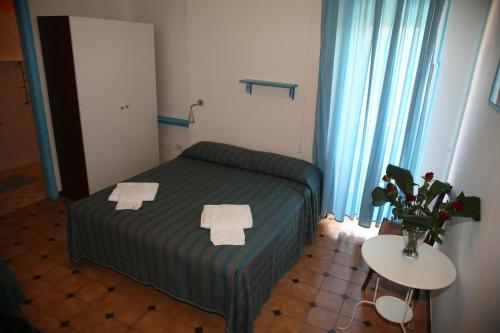 a bedroom with a bed and a table with towels on it at Affittacamere Via Muraglione in Ventotene