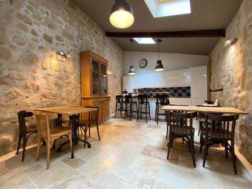 un bar avec des tables et des chaises en bois dans un restaurant dans l'établissement Logis des Jurats, à Saint-Émilion