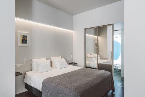 een slaapkamer met een groot bed en een spiegel bij Hotel Pilar in Antwerpen